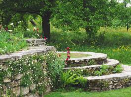 Ansprechend gestaltet sind Treppen in jedem Garten ein Blickfang, so auch diese mit halbkreisfrmigen Steinstufen.