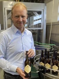 Kolja Bitzenhofer, der Leiter des Staatsweingutes Freiburg, präsentiert einen Weißburgunder, der in Bierflaschen abgefüllt wurde.