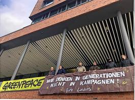 Pfiffige Aktion: Mitglieder von „Land schafft Verbindung” demonstrieren an der Zentrale von Greenpeace in Hamburg mit einem Transparent.